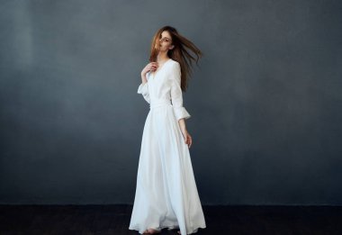 Beyaz elbiseli güzel bir kadın zarif bir dans modeli.