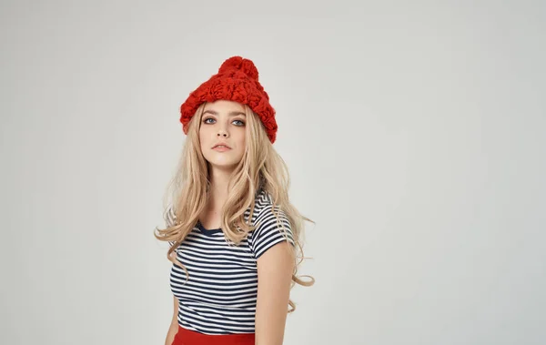 Mujer rubia en camiseta a rayas y retrato sombrero rojo sobre fondo claro recortado ver — Foto de Stock
