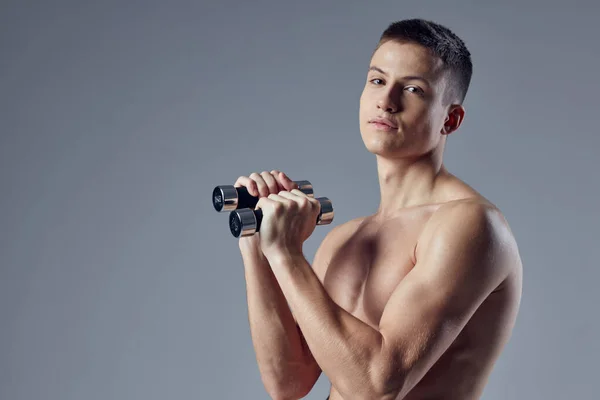 Homme sportif avec haltères dans les mains entraînement muscles exercice biceps — Photo