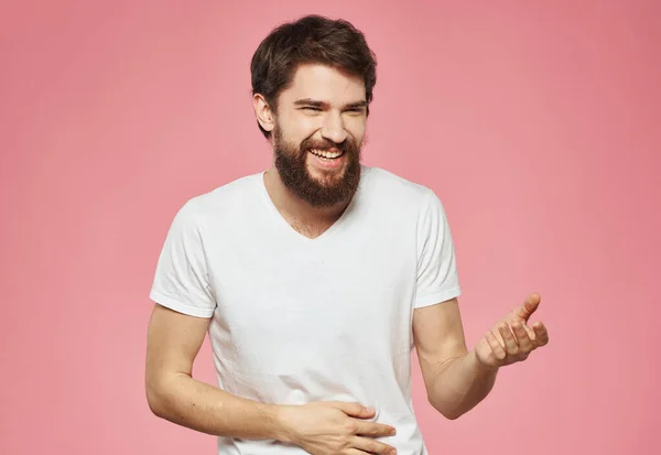 Emocional hombre haciendo gestos con las manos sobre un fondo rosa recortado vista — Foto de Stock
