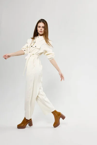 Μοντέρνα γυναίκα σε λευκό jumpsuit σε ένα ελαφρύ φόντο κομψό ρούχα μοντέλο συναισθήματα — Φωτογραφία Αρχείου