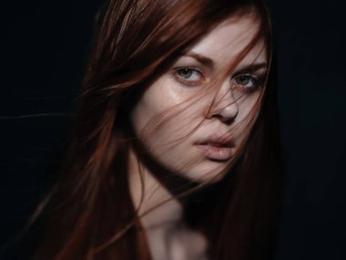 Siyah arka planda kızıl saçlı romantik bir kadın. Yakın plan portresi.