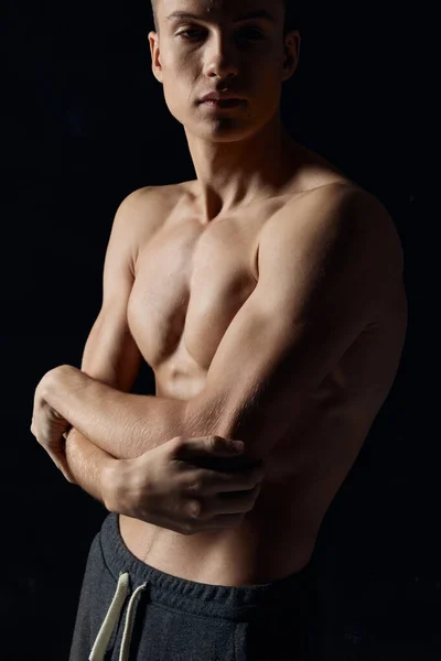 Sport facet na czarnym tle nagi torso fitness gimnastyka ramiona skrzyżowane na jego klatce piersiowej — Zdjęcie stockowe