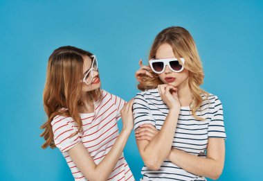 İki kız arkadaş duygularının uyuşmazlığı mavi arka planda tartışır