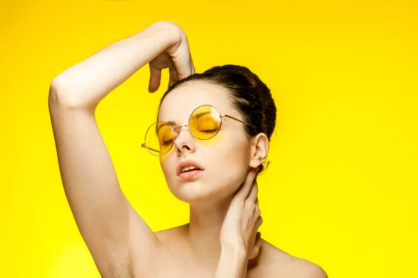 Kvinna med bara axlar klar hud gula glasögon hand gest — Stockfoto