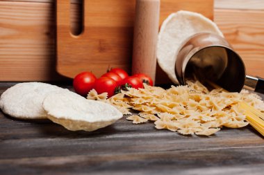 Tahta bir masada makarna kiraz domatesleri mutfak gereçleri pişirme