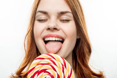 Ağzı açık duygusal bir kadın. Büyük renkli bir lolipop. 