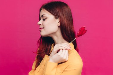 Kalbi sopada ve pembe arka planda olan duygusal bir kadın Sevgililer Günü bej gömleği