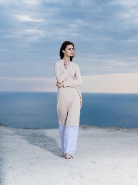 Kadın, arka planda okyanusta, doğa yollarında seyahat eder.