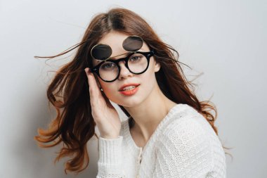 Kızıl saçlı, gözlüklü, kırmızı dudaklı, göz alıcı, izole bir arka plan.