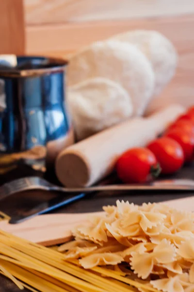 Pasta besprenkeld op de tafel tomaten door de Italiaanse keuken — Stockfoto