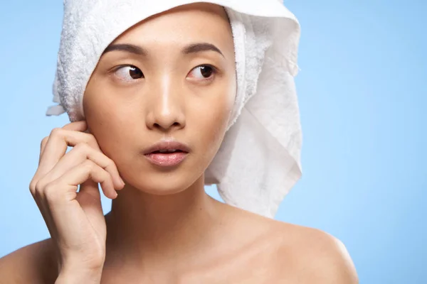 Mooie vrouw handdoek op hoofd close-up schone huid gezondheid blauwe achtergrond — Stockfoto