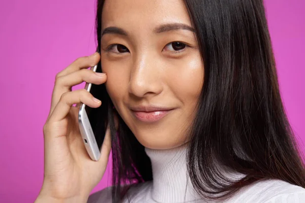 Женщина азиатский внешний вид телефон связи интернет образ жизни розовый фон — стоковое фото