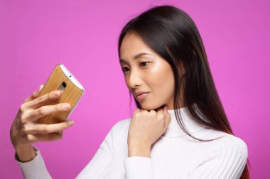 Şirin esmer telefon elinde internet teknolojisi yaşam tarzı pembe arka plan