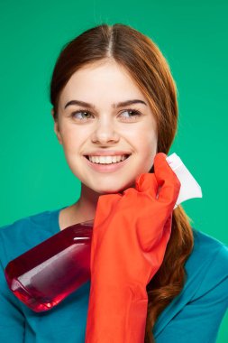 Neşeli güzel kadın deterjan ev temizleme servisi yeşil arka plan