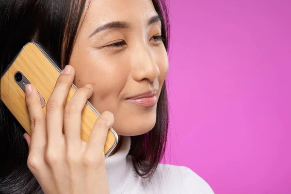 woman asian appearance phone close-up smile pink technology background