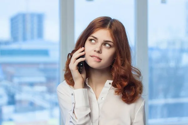 Веселая деловая женщина разговаривает по телефону окно офиса на заднем плане — стоковое фото