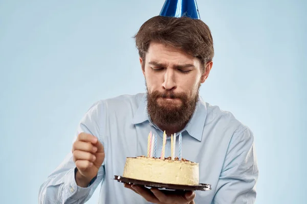 Торт в тарелке и именинник с шапкой на голове синей спинкой — стоковое фото