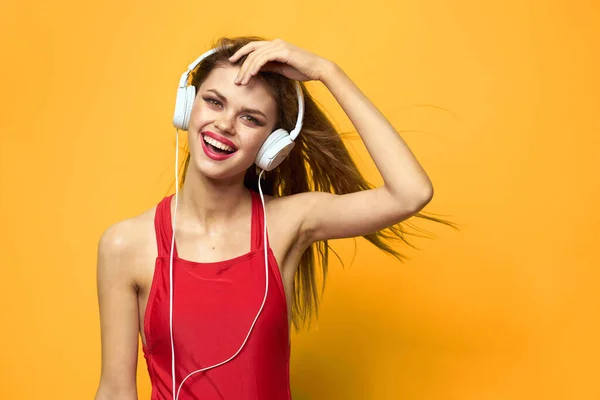 Femme émotionnelle dans les écouteurs blancs écoute de la musique fun style de vie fond jaune — Photo
