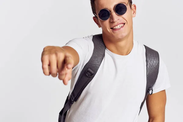 Hombre guapo con mochila en la espalda gesto con las manos en una camiseta y con gafas Copiar espacio retrato —  Fotos de Stock