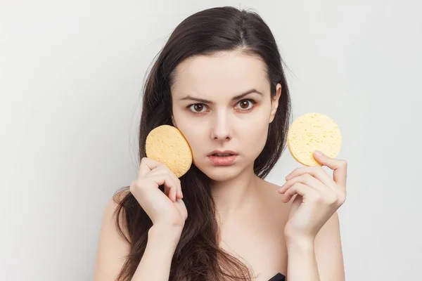 Morena atraente com cabelo fluindo ombros nus esponja perto do rosto — Fotografia de Stock