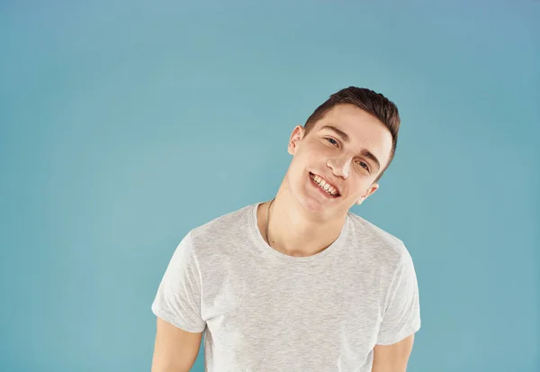 Cheerful man in white T-shirt emotions gestures with hands blue background — Stock Photo, Image