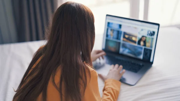 Kvinna som ligger i sängen framför laptop arbetar hemma internet — Stockfoto