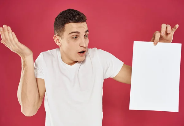 Man met een flyer in zijn hand op een rode achtergrond reclame mockup — Stockfoto