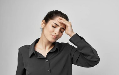 Yüzünde hoşnutsuzluk ifadesi olan esmer bir kadın.