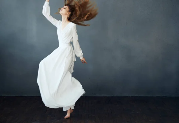 Mujer en vestido blanco largo sobre fondo gris baile modelo emociones — Foto de Stock