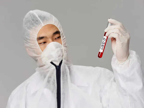 Asian man holding covid-19 research blood test greine background — стокове фото