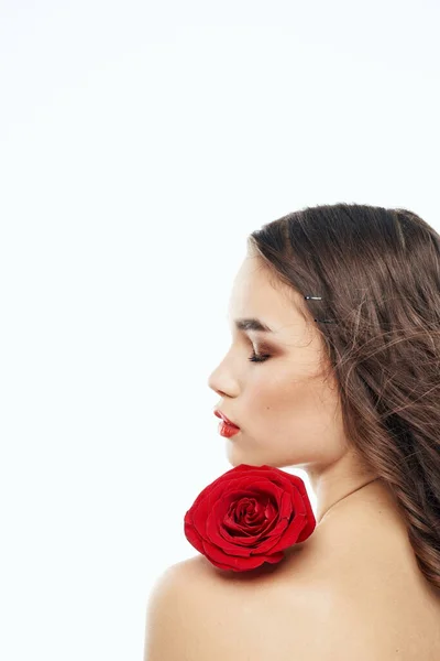 Zadní pohled na atraktivní brunetku s červenou růží na nahém rameni — Stock fotografie