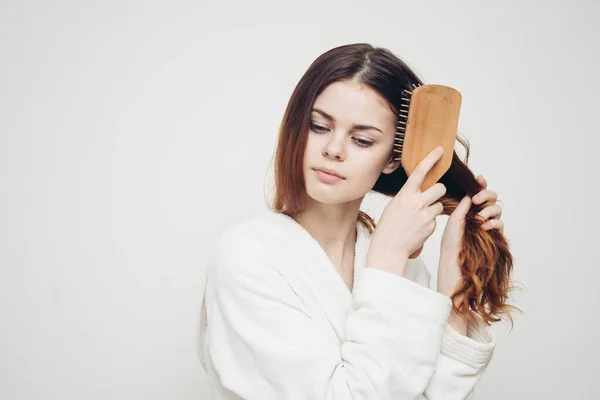 Γυναίκα με λευκή ρόμπα με ξύλινη χτένα και μακριά μαλλιά μοντέλο — Φωτογραφία Αρχείου