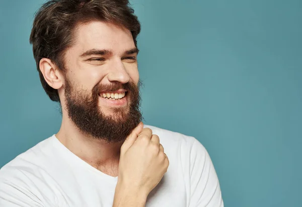 Portret van een man blauwe achtergrond close-up bijgesneden uitzicht wit t-shirt knappe glimlach — Stockfoto