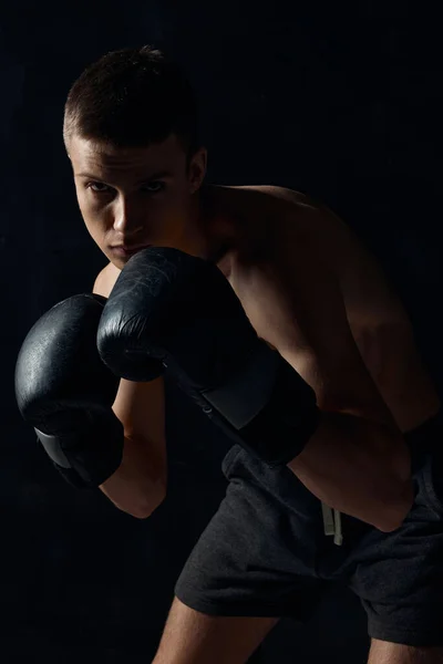 Uomo in guanti da boxe su sfondo nero allenamento bodybuilder fitness — Foto Stock