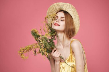 Şapkalı güzel bir kadın. Çiçek buketi. Tatilde.