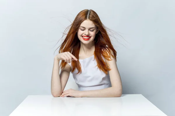 웃으며 테이블에 앉아 있는 빨간 머리 여자 — 스톡 사진