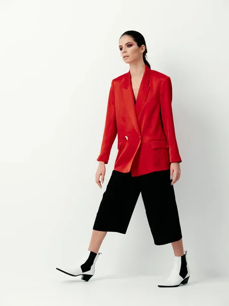 Brunetka w czerwonej kurtce jasny makijaż glamour dekoracji lekkie tło — Zdjęcie stockowe