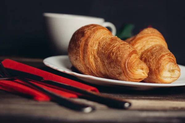 Croissants auf weißem Teller rote Kaffeetasse — Stockfoto