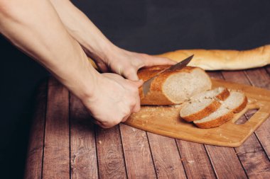 Kesme tahtası mutfağında taze bir somun dilimliyorum.