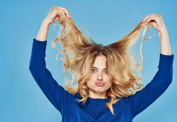 Bonita mulher segurando cabelo emoções estilo de vida recortado vista azul fundo — Fotografia de Stock