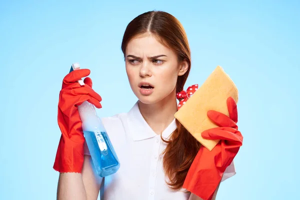 Mujer con suministros de limpieza en las manos de la entrega de servicios profesionales fondo azul — Foto de Stock