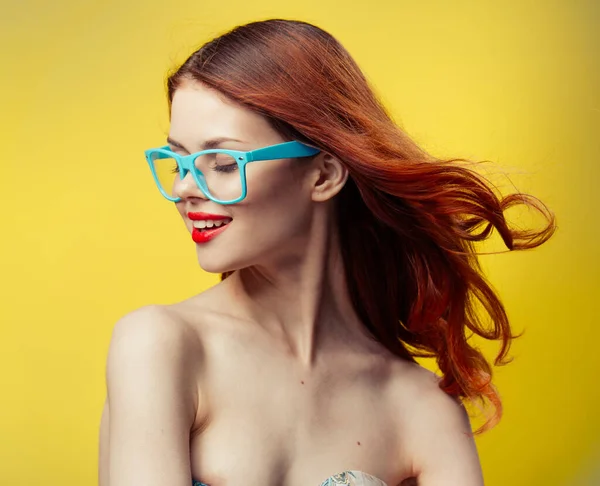 Donna in occhiali blu su sfondo giallo ritratto — Foto Stock