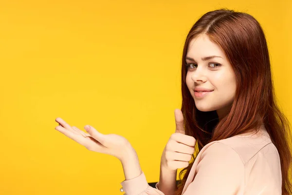 Vrolijk mooi vrouw holding hand in voor haar emotie charme geel achtergrond — Stockfoto