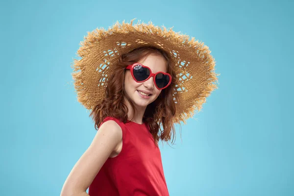 Flicka i en strand Halmhatt i solglasögon lockigt hår kul blå bakgrund — Stockfoto
