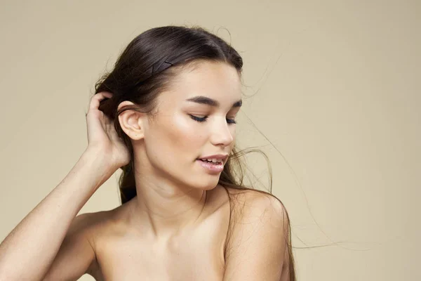 Mulher bonita ombros nus cosméticos pele limpa cuidado do cabelo fundo bege — Fotografia de Stock