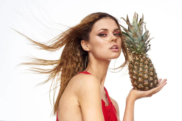 Mulher com abacaxi em mãos ondulado cabelo vermelho t-shirt frutas verão férias luz fundo — Fotografia de Stock