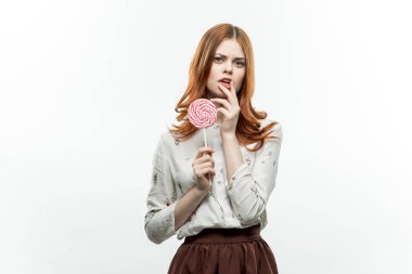 Ellerinde lolipopla çekici bir kadın. Keyif alıyor.