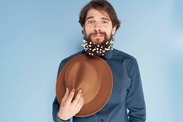 Tişörtlü, sakallı, şapkalı, zarif, mavi arka planlı bir adam. — Stok fotoğraf