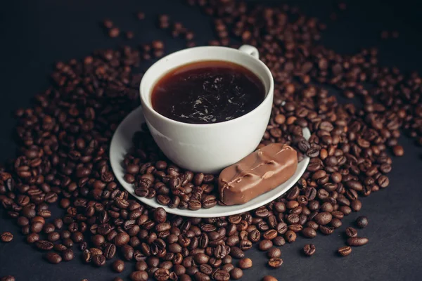 Una taza de café y una barra de chocolate en un platillo arabica frijoles variedad bebida — Foto de Stock